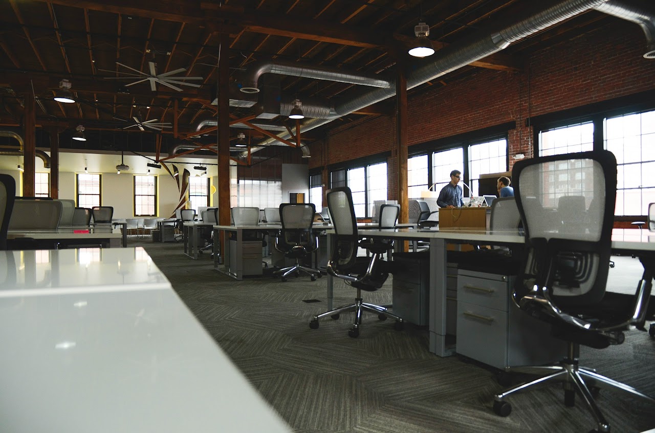 Corporate office space with two people discussing in the background